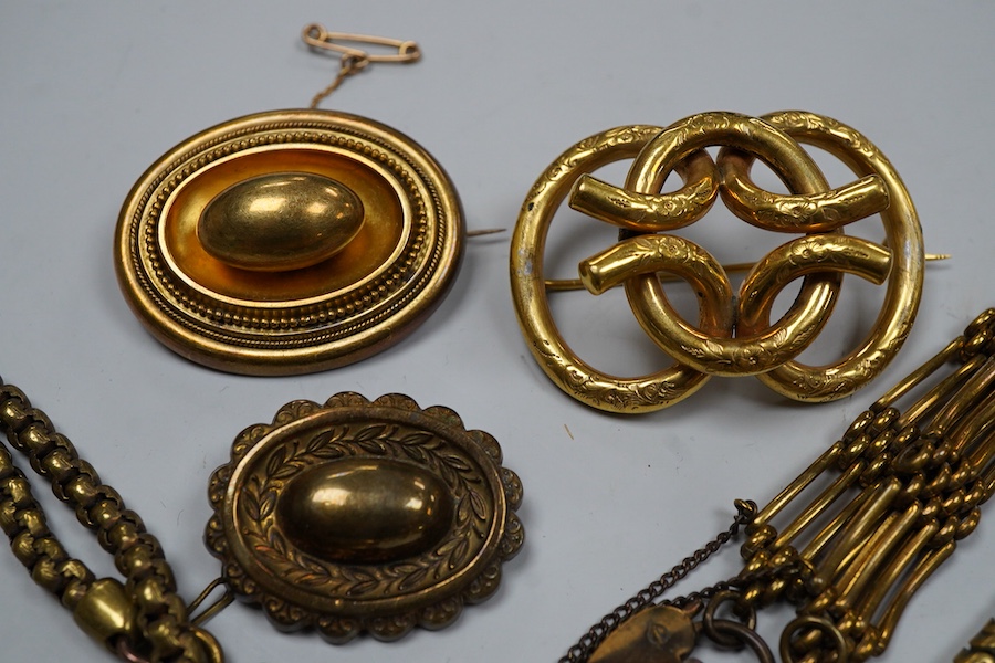 A group of gilt metal/pinchbeck jewels, 19th and early 20th century, comprising: a brooch of knotted design; two gate bracelets; a fancy link bracelet; an open-faced pocket watch; two oval panel brooches, and two watch c